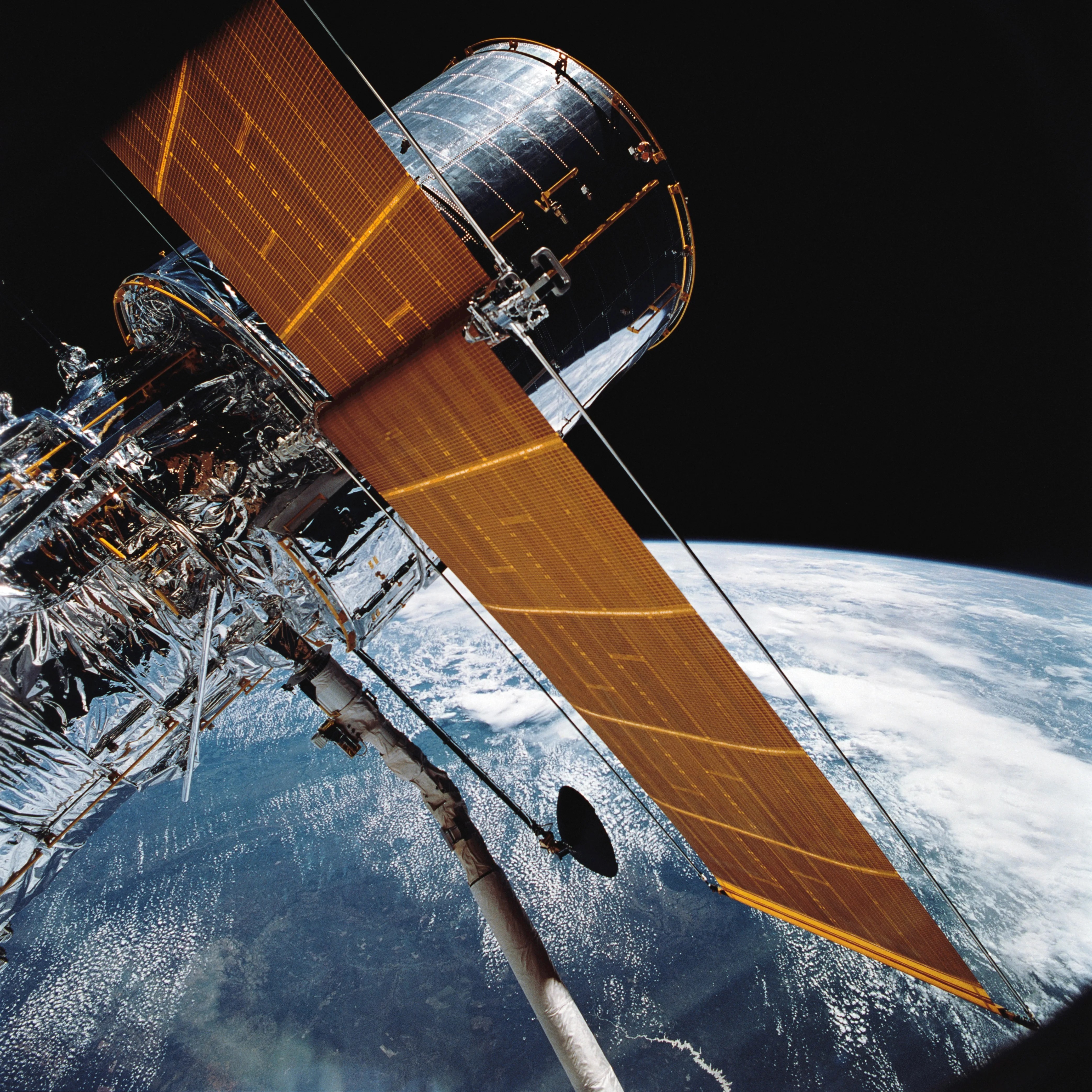 Hubble Uzay Teleskobu, 25 Nisan 1990’da Discovery’nin robot kolunda; STS-31 görevi. Gerçek görev fotoğrafı.